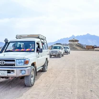 Convoy of 4x4 Jeeps crossing the desert with mountains in the background on the Super Safari Hurghada