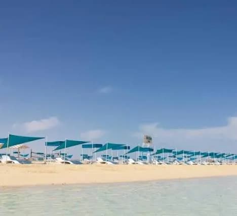 Row of teal beach cabanas along the sand at Bianca Island