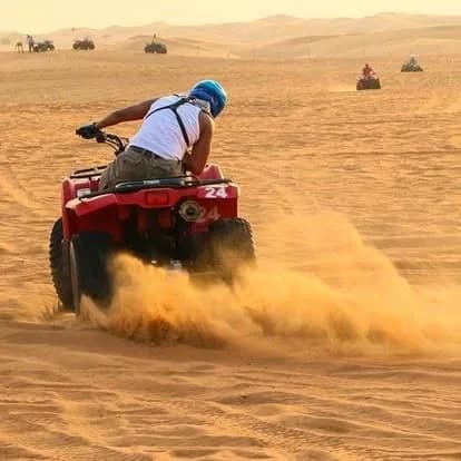 Rider kicking up sand on a quad bike in the desert